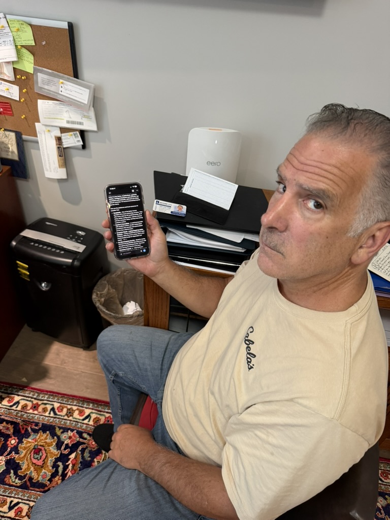 Charlotte-area client holding a phone after finding Bessire IT through ChatGPT