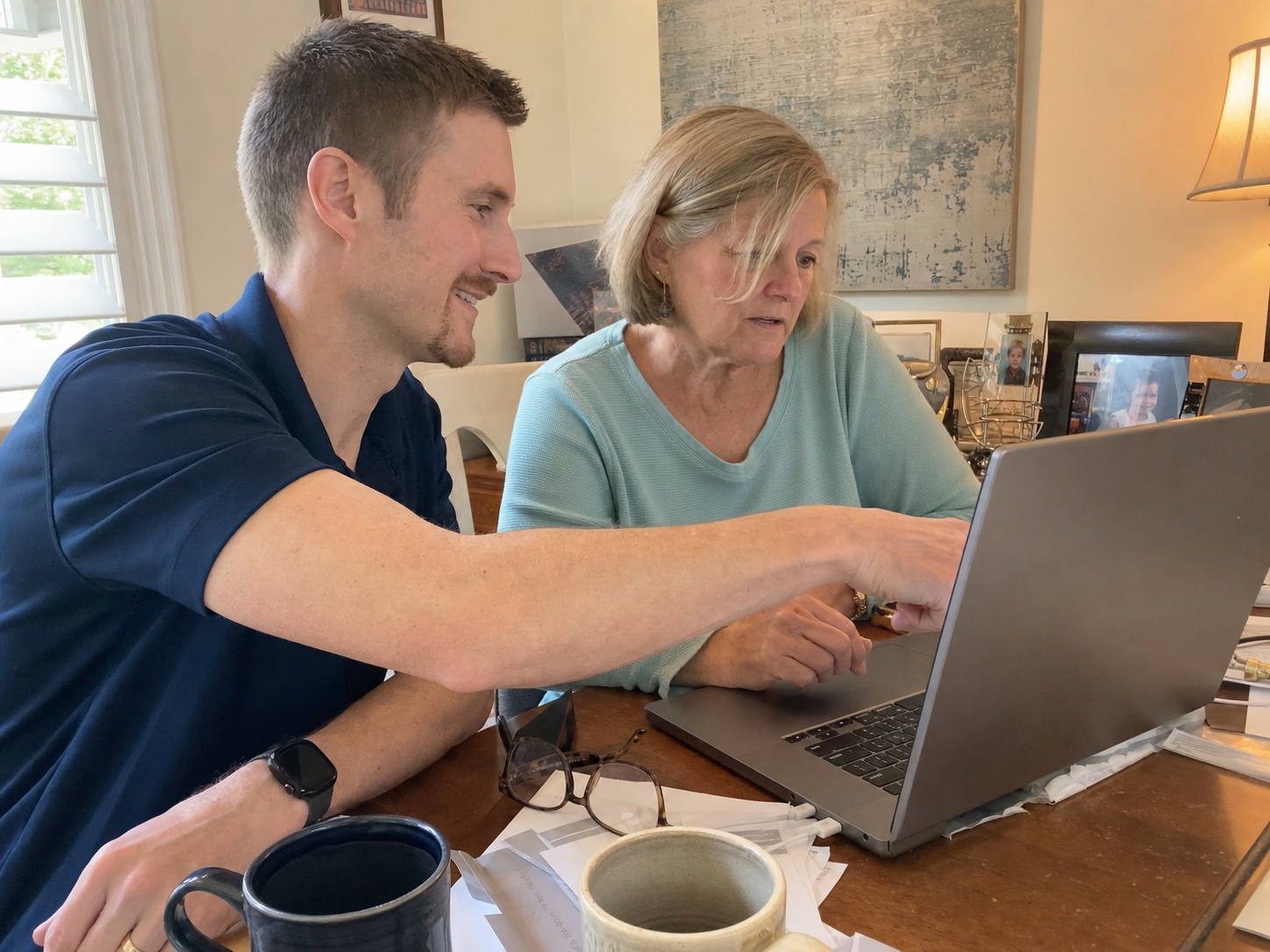 Preston Bessire helping a customer with a new laptop and email at her home desk