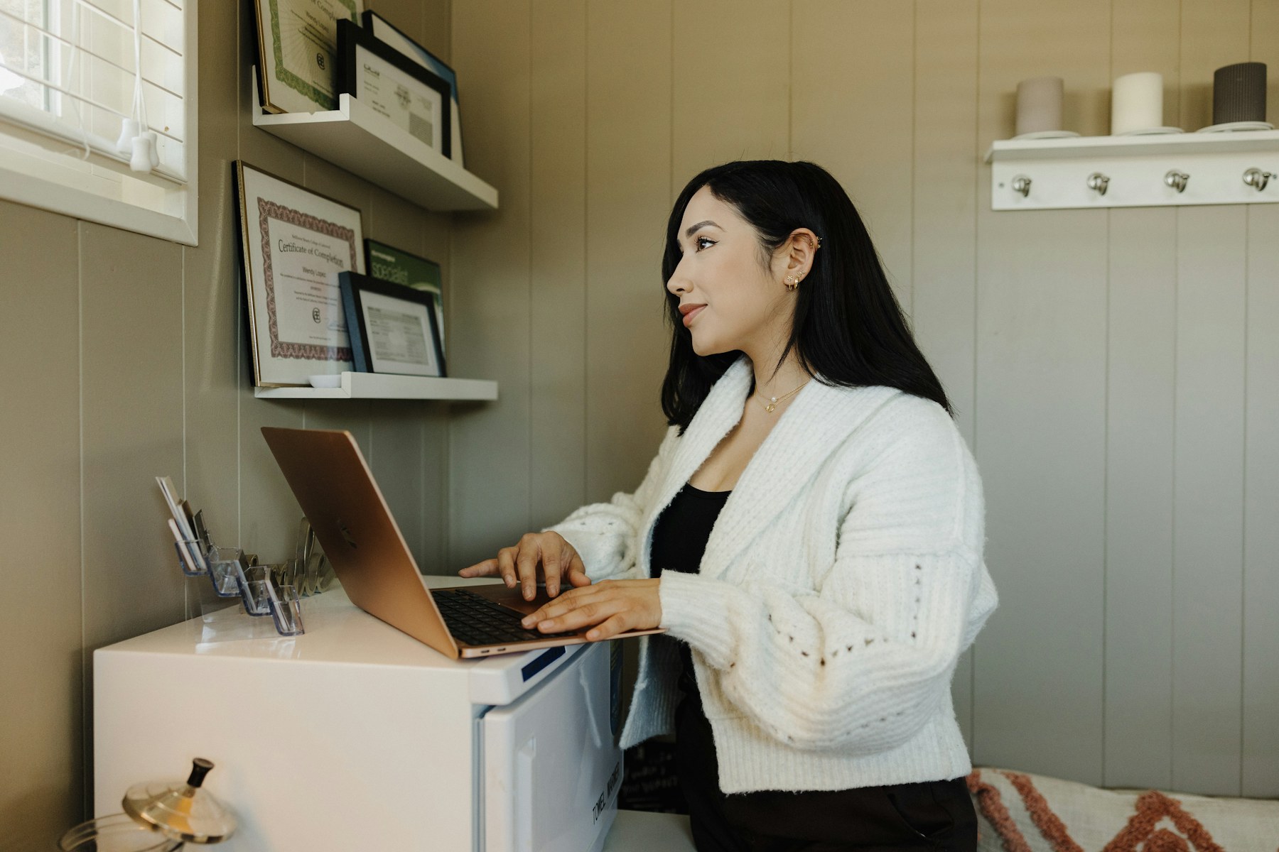 Small-business owner working at a laptop in her real workspace